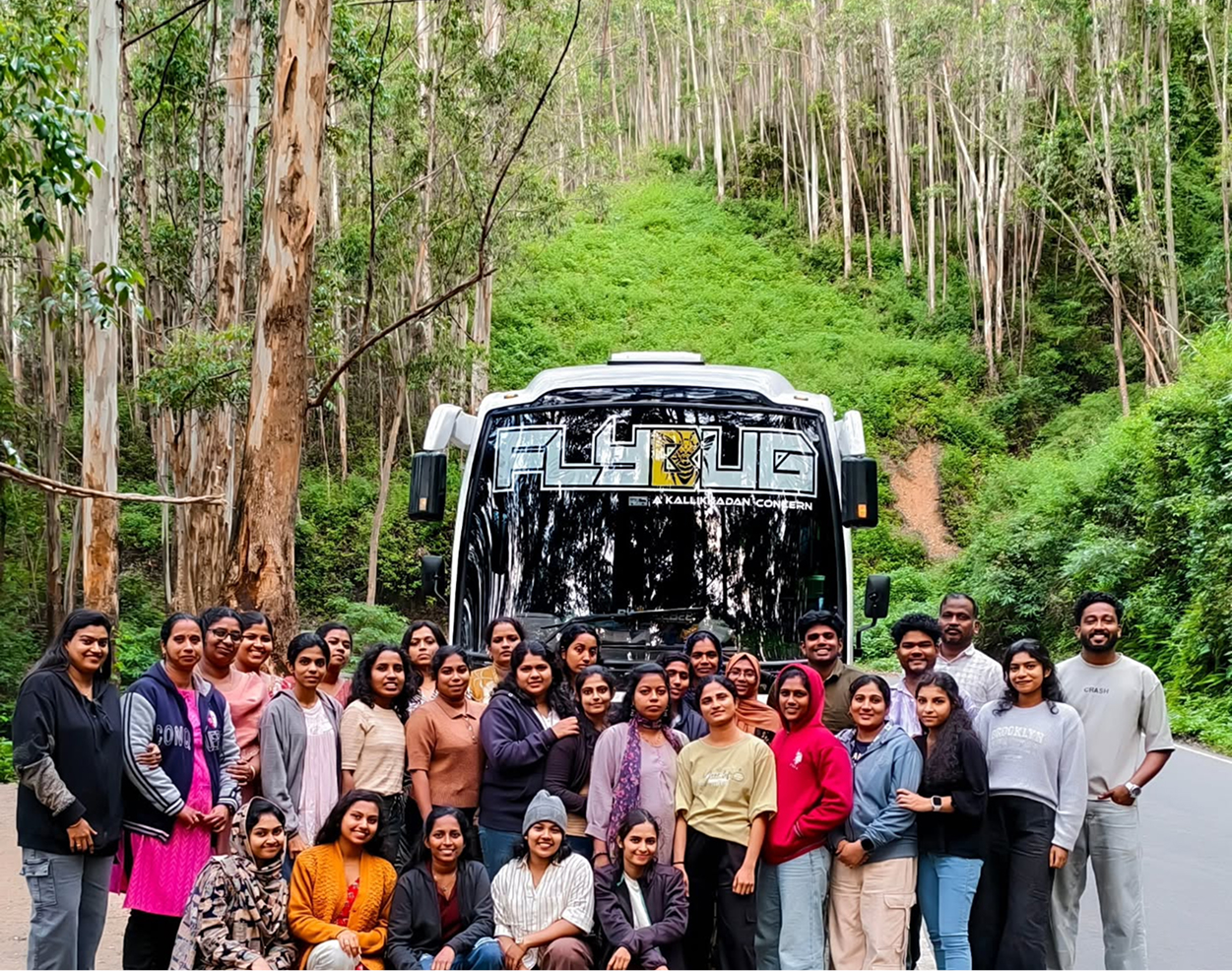 A group of travellers gathered beside a JourneyX tourist coach.