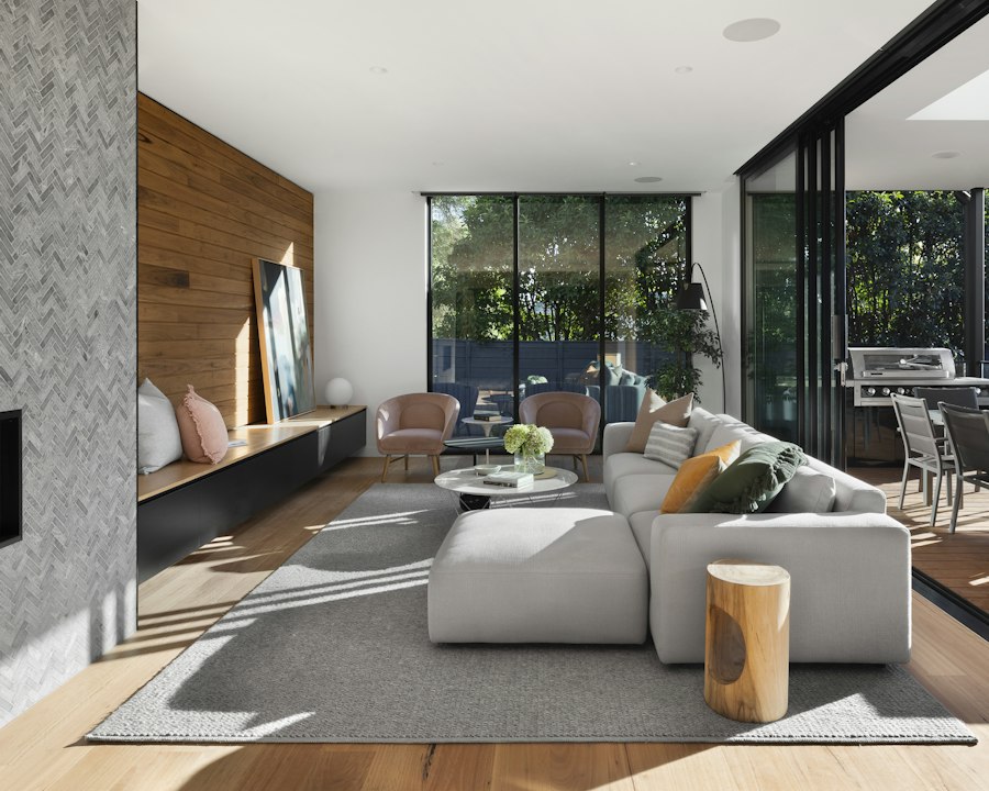 Sneha Iyer’s interior: a warm living space with timber wall panelling opening onto a garden