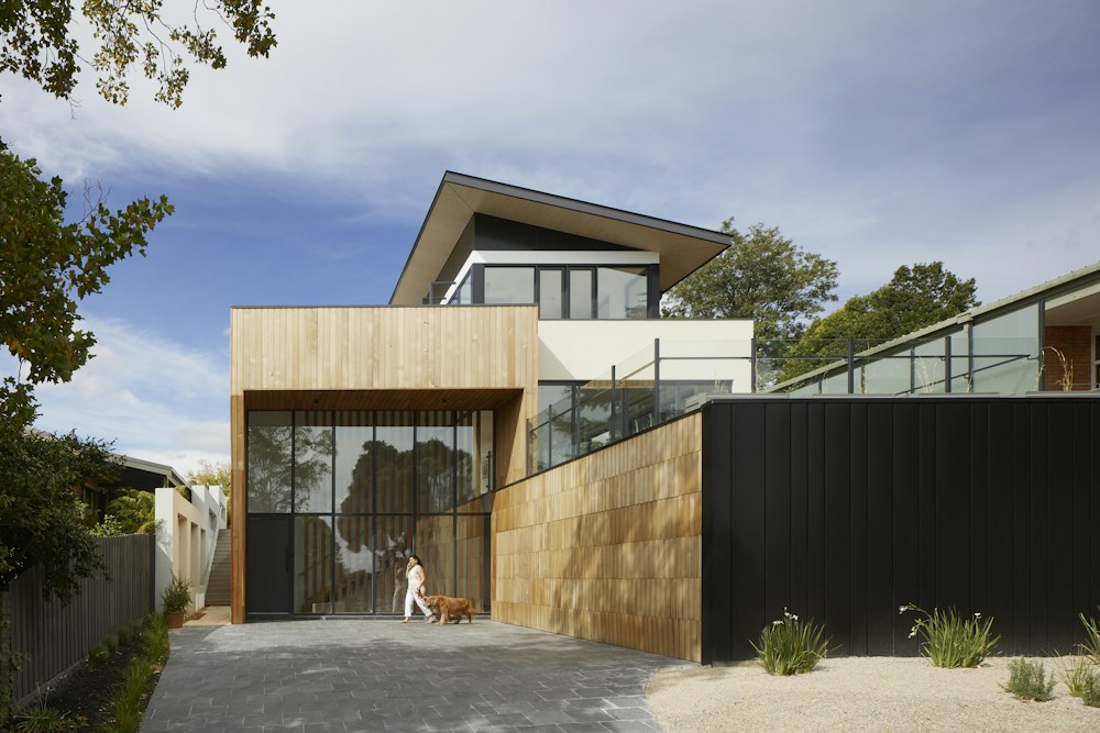 Timber-clad residence with a cantilevered upper storey and full-height glazing