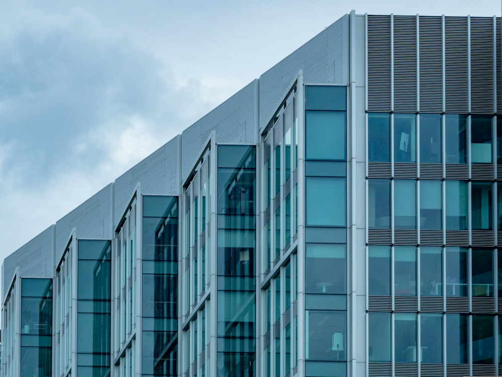 Contemporary commercial office building with a glass facade against a blue sky