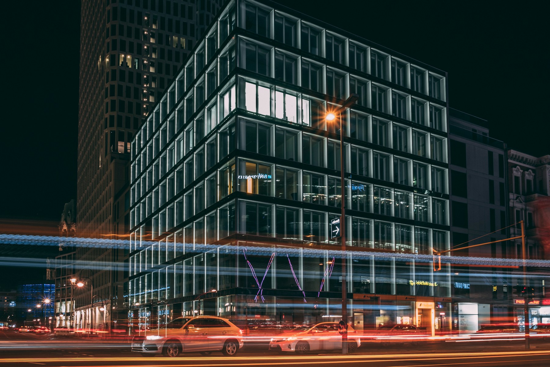 Glass-fronted commercial office building lit from within at night